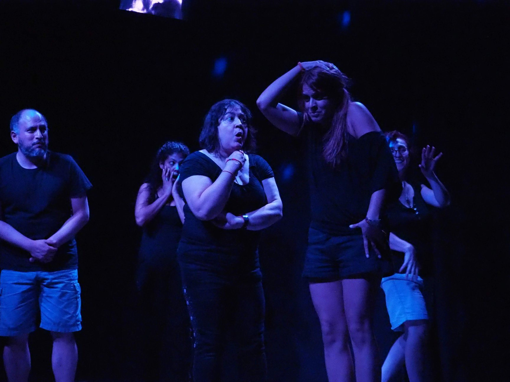 Alumnos realizando una dinámica de improvisación teatral en el escenario
